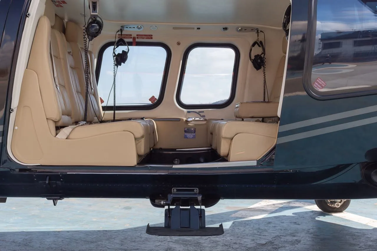 Asientos de cuero beige y auriculares en la cabina del helicóptero