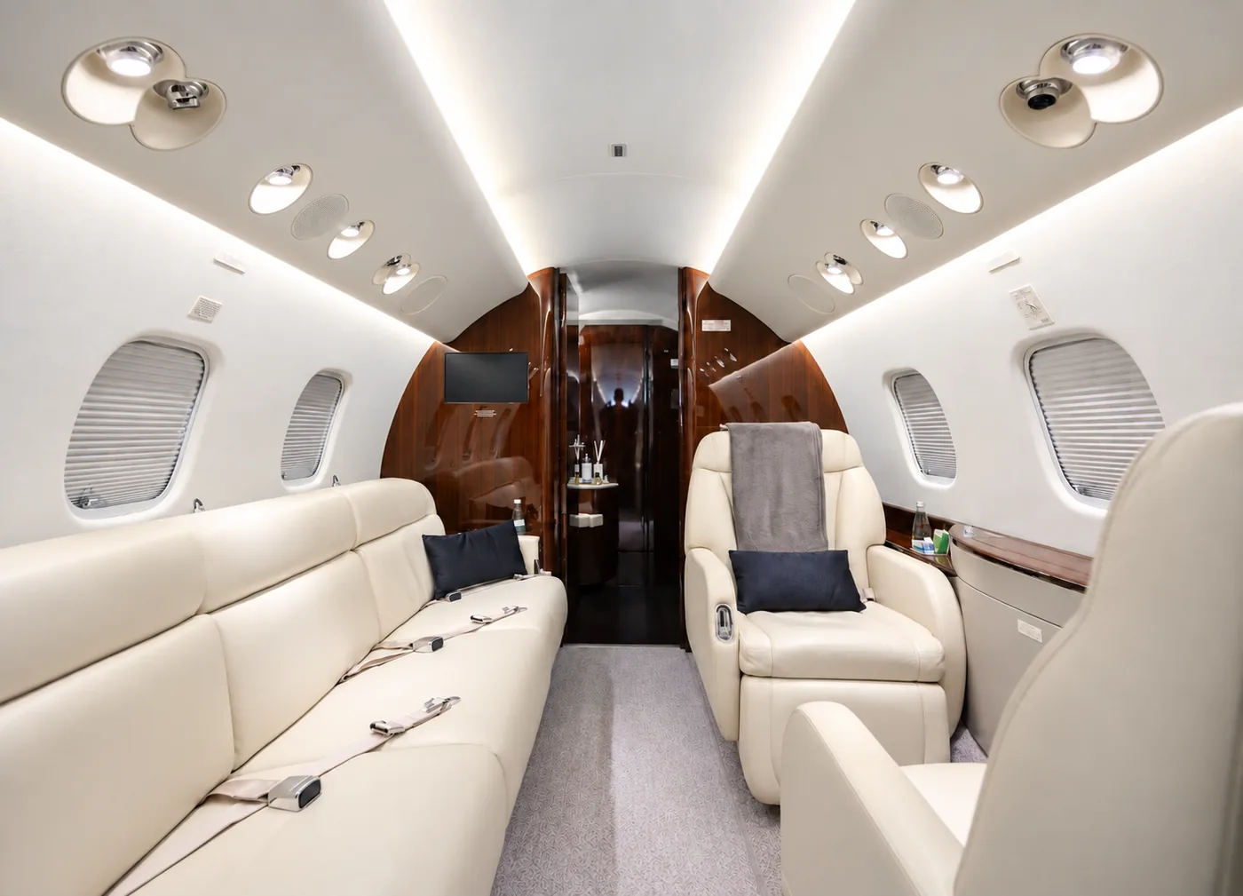 Cabina de jet ejecutivo con sofá y butacas de cuero claro